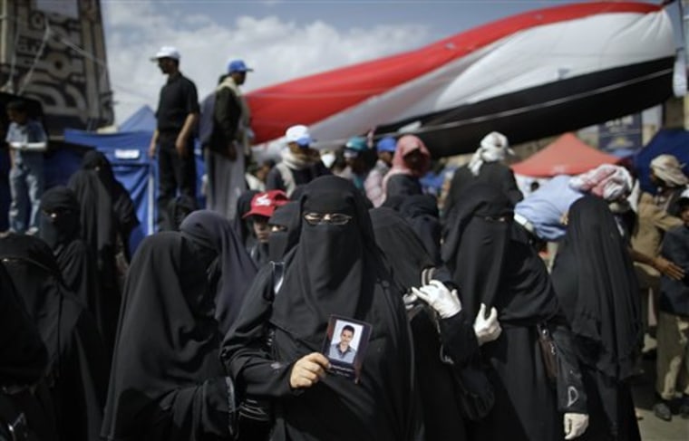 A female anti-government protester, center, looks on during a demonstration demanding the resignation of Yemeni President Ali Abdullah Saleh, in Sanaa, Yemen, on Sunday. Suspected al-Qaida gunmen killed four Republican Guard soldiers on Sunday in the mountainous central province of Marib, security officials said. Also Sunday, the U.S. government, citing terrorism and civil unrest, advised Americans not to travel to Yemen and said Americans already in the impoverished Arab nation should leave. 